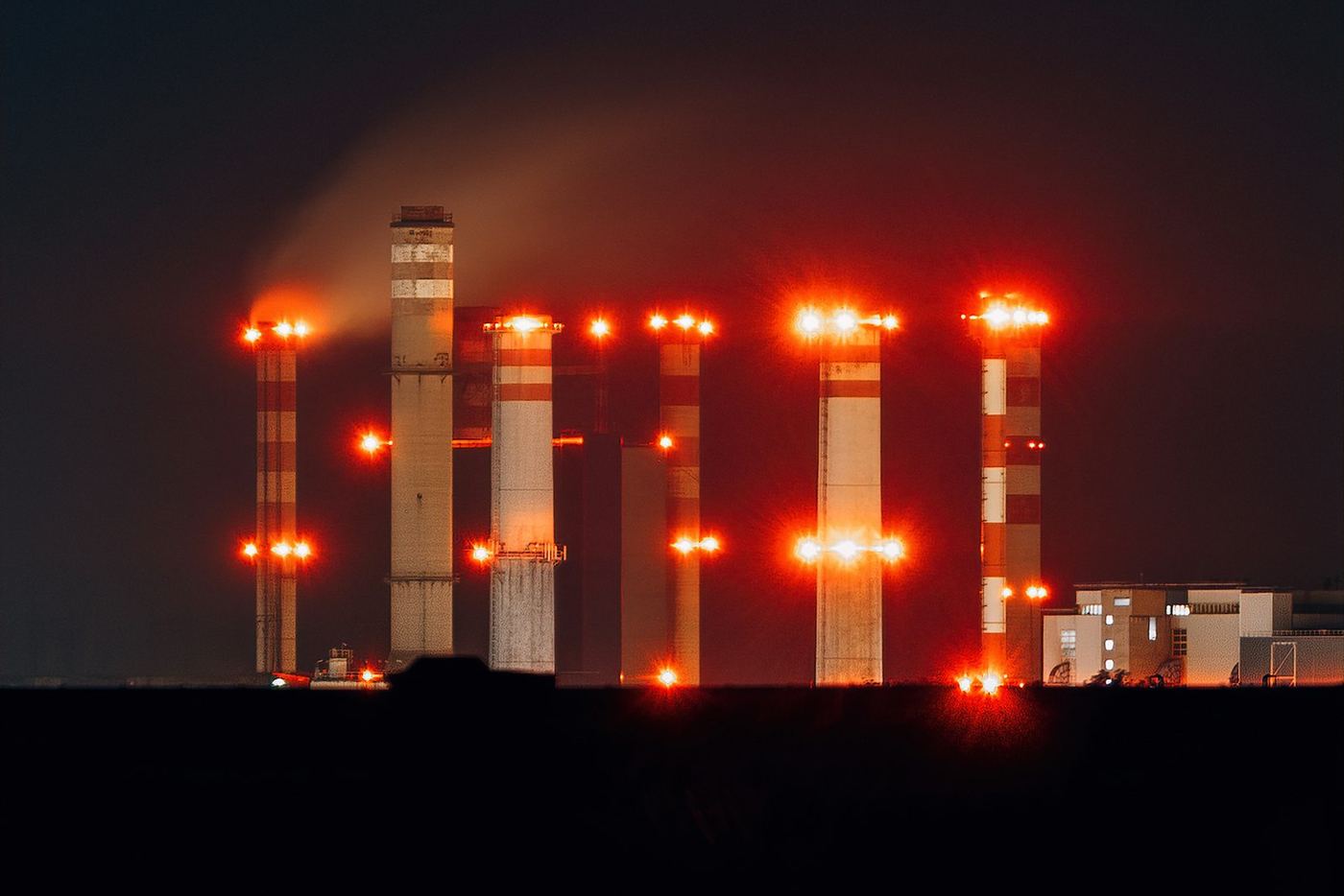 Industriecomplex met rode lichten bij nacht